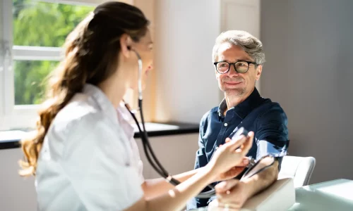 Doctor Measuring Blood Pressure Of Male Patient